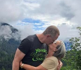 Elizabeth and her husband sharing an anniversary kiss